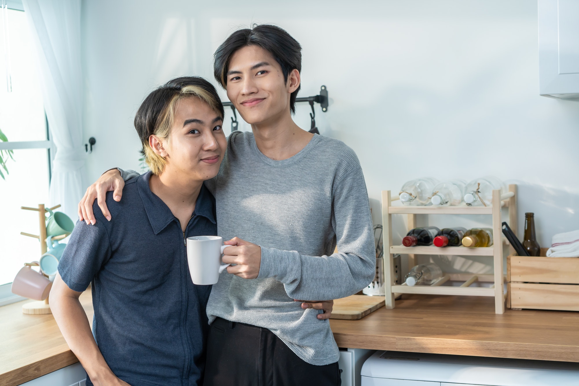 Portrait of Asian handsome male gay couple drinking coffee in morning.
